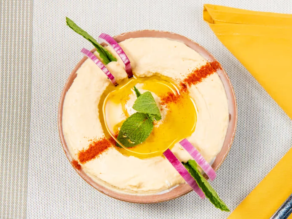 Hummus - Our signature creamy hummus made from scratch with premium chickpeas, tahini, lemon juice, and a drizzle of extra-virgin olive oil.